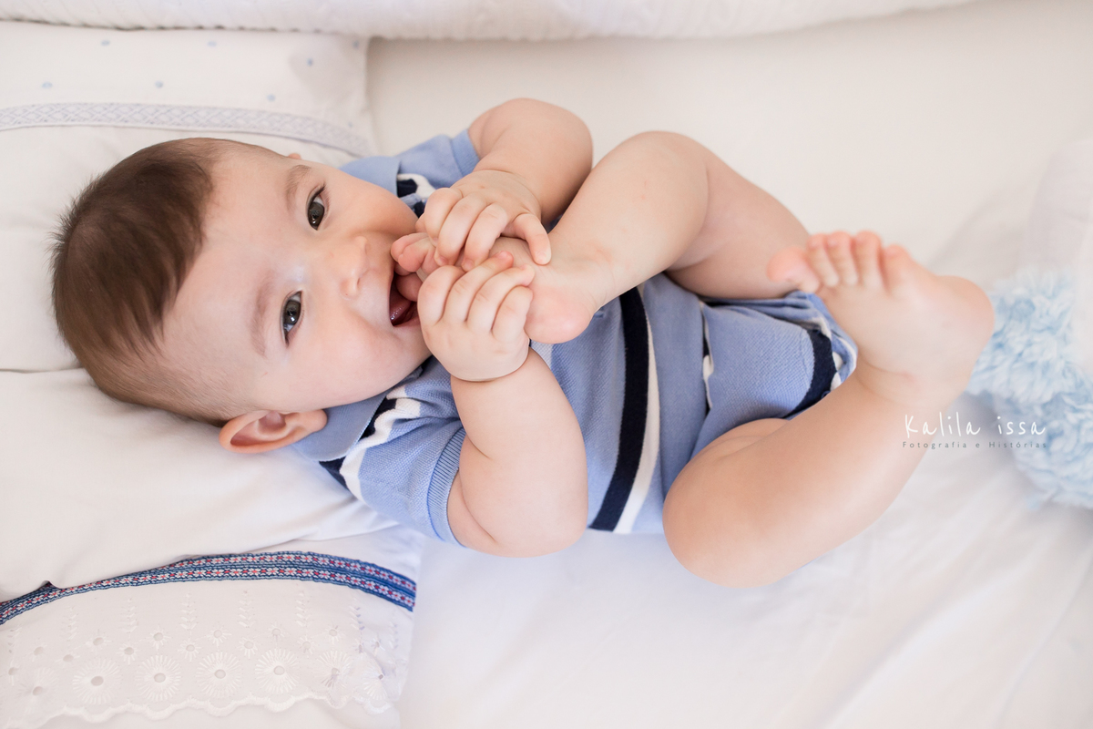 fotos atemporais de acompanhamento mensal em casa bebê com o pezinho na boca