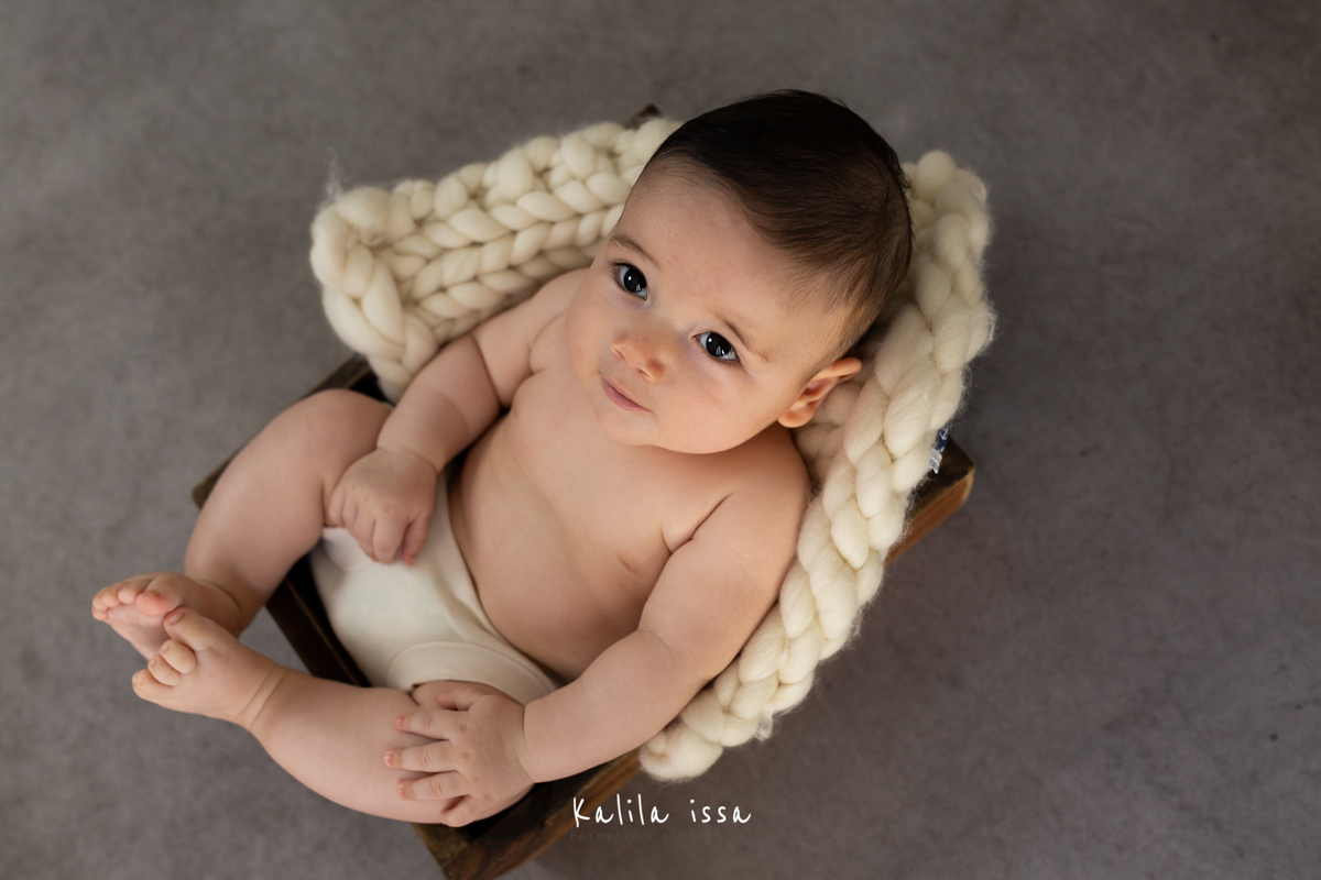 bebê de 6 meses  fotografado no o fundo em tecido da wentz . 