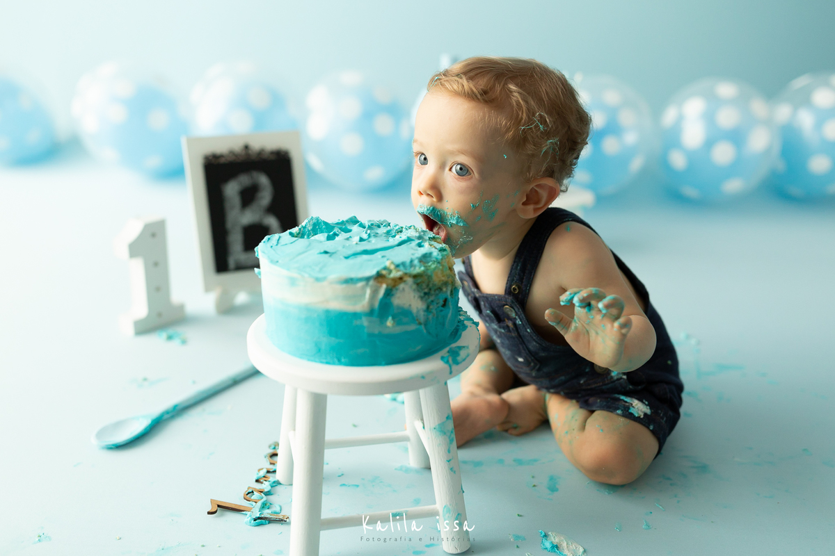 criança come o bolo do smash the cake no estúdio kalila issa