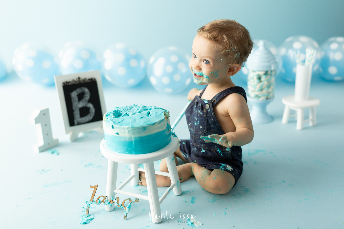 criança fica feliz ao comer o bolo do da sessão fotográfica do smash the cake no estúdio kalila issa