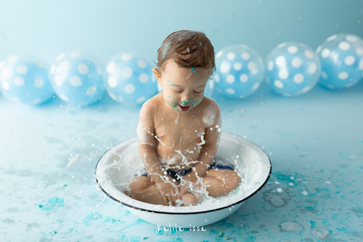 criança toma banho na sessão fotográfica de splash logo após o smash the cake
