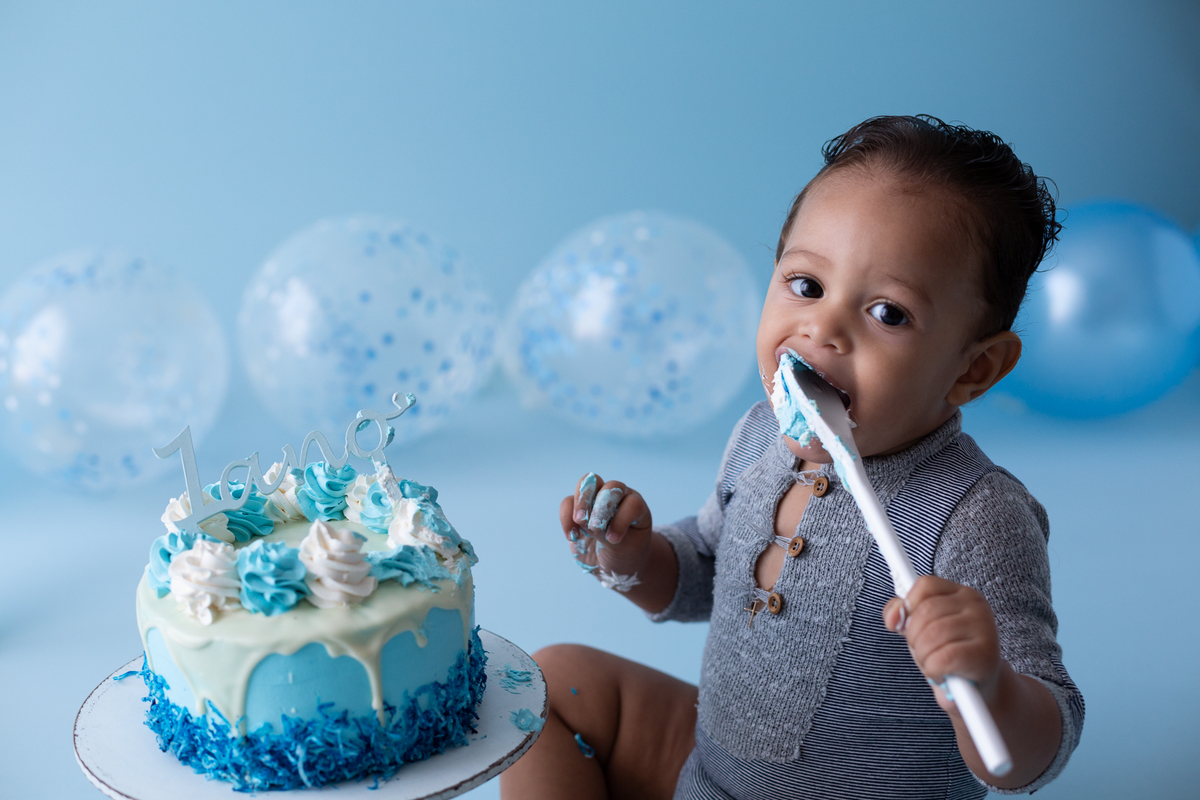 bolo padaria colombina bairro floresta para aniversário de 1 aninho, menino leva a colher de pau com o bolo na boca e gosta do sabor 