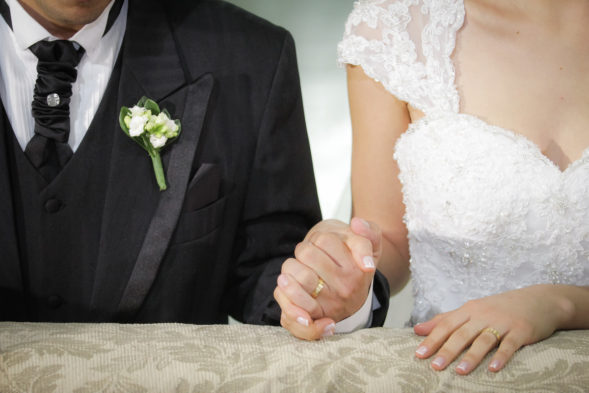Noivos de mãos dadas durante casamento 

