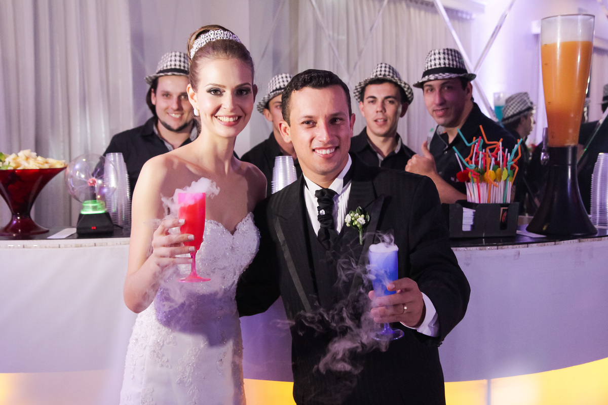 Noivos com copos coloridos de drinks