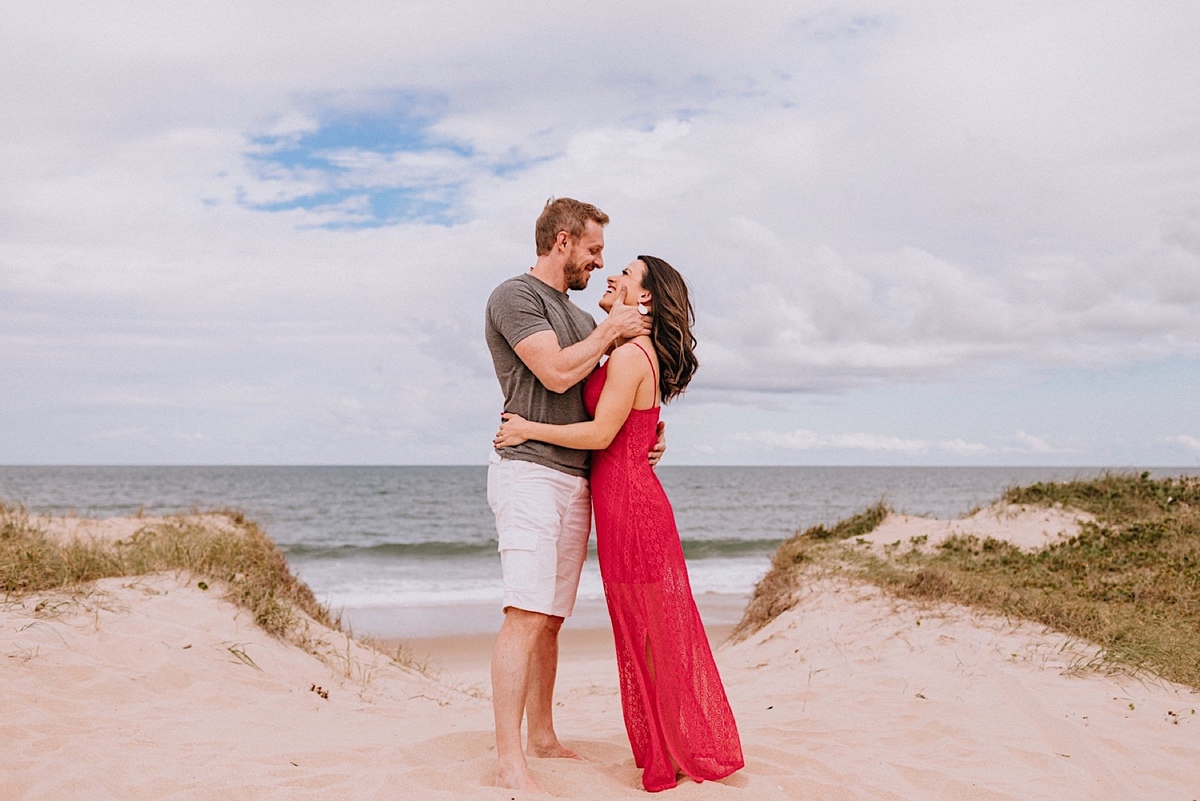 Ensaio de Casal da Jacqueline e do Romulo em São Francisco do Sul em Santa Catarina, ensaio na praia, ensaio nas dunas de são francisco, ensaio nas pedras da praia, ensaio na praia no final da tarde crossfit
