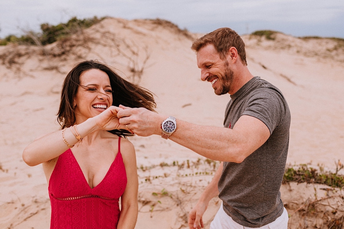 Ensaio de Casal da Jacqueline e do Romulo em São Francisco do Sul em Santa Catarina, ensaio na praia, ensaio nas dunas de são francisco, ensaio nas pedras da praia, ensaio na praia no final da tarde crossfit