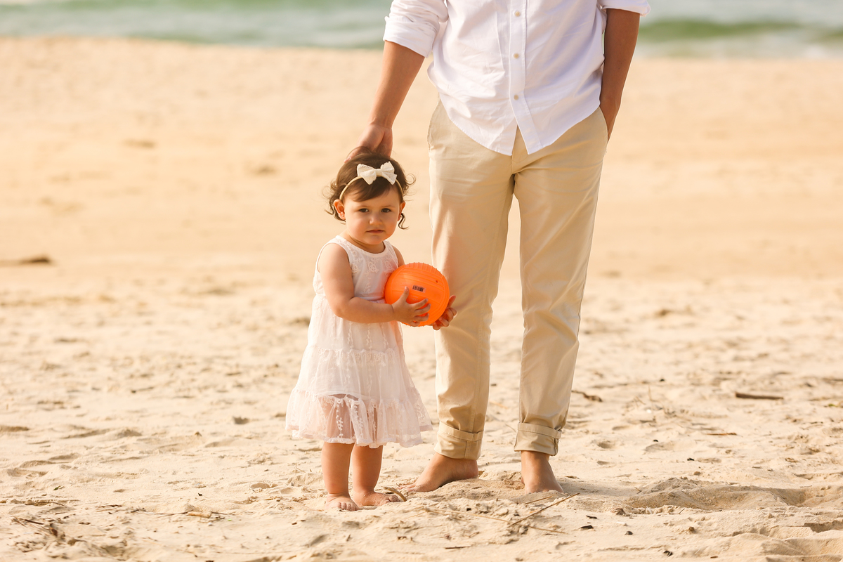 pai e filha na praia, criança com bola na praia,