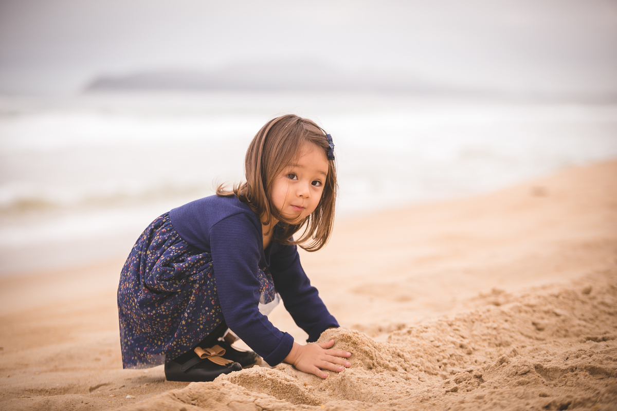 criança mexendo na areia da praia floripa