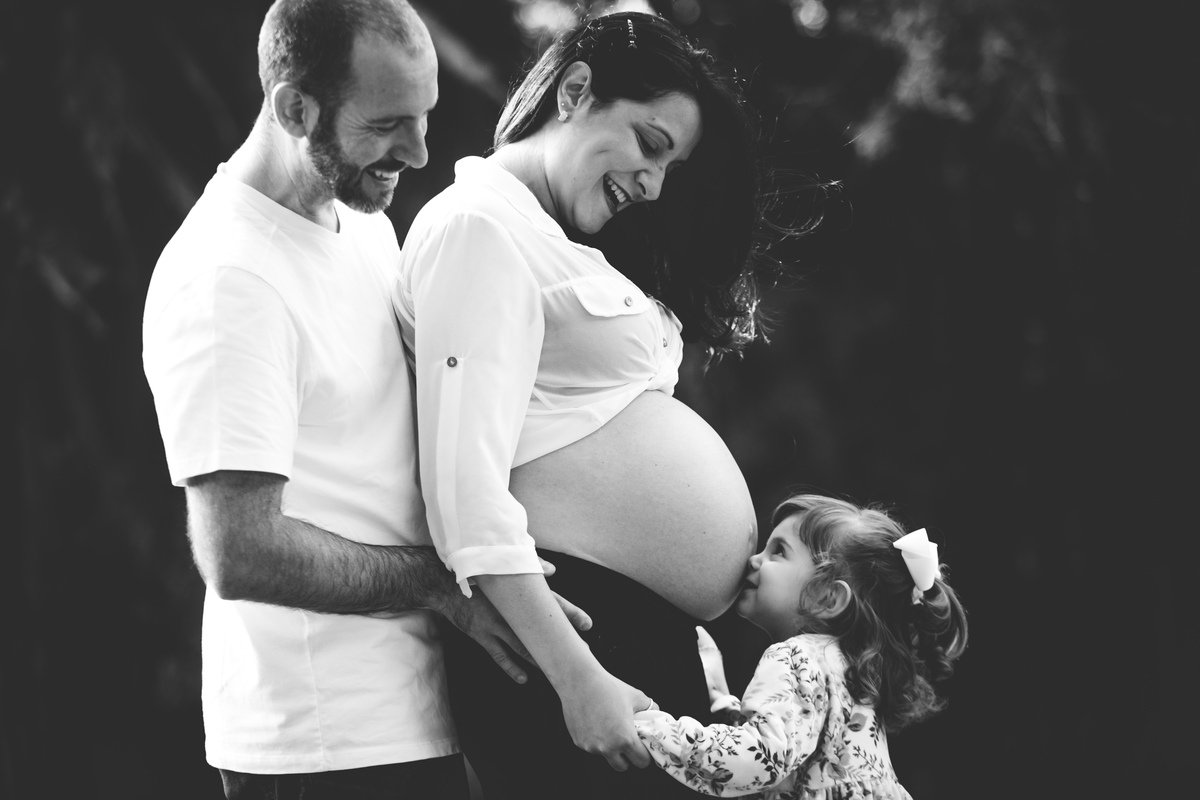 criança beijando a barriga da mae