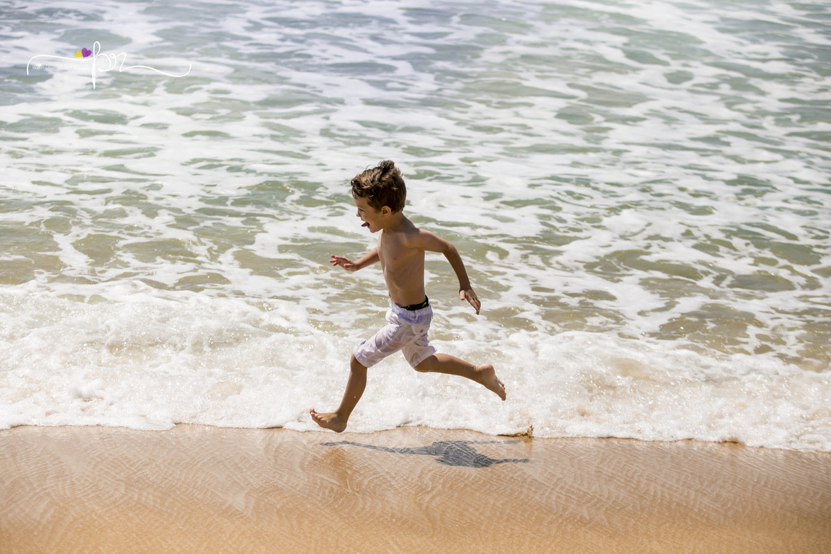 criança correndo na praia floripa