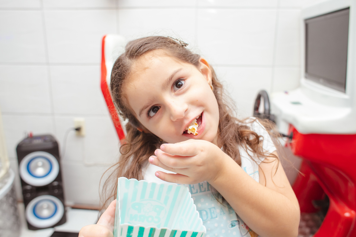 criança comendo pipoca
