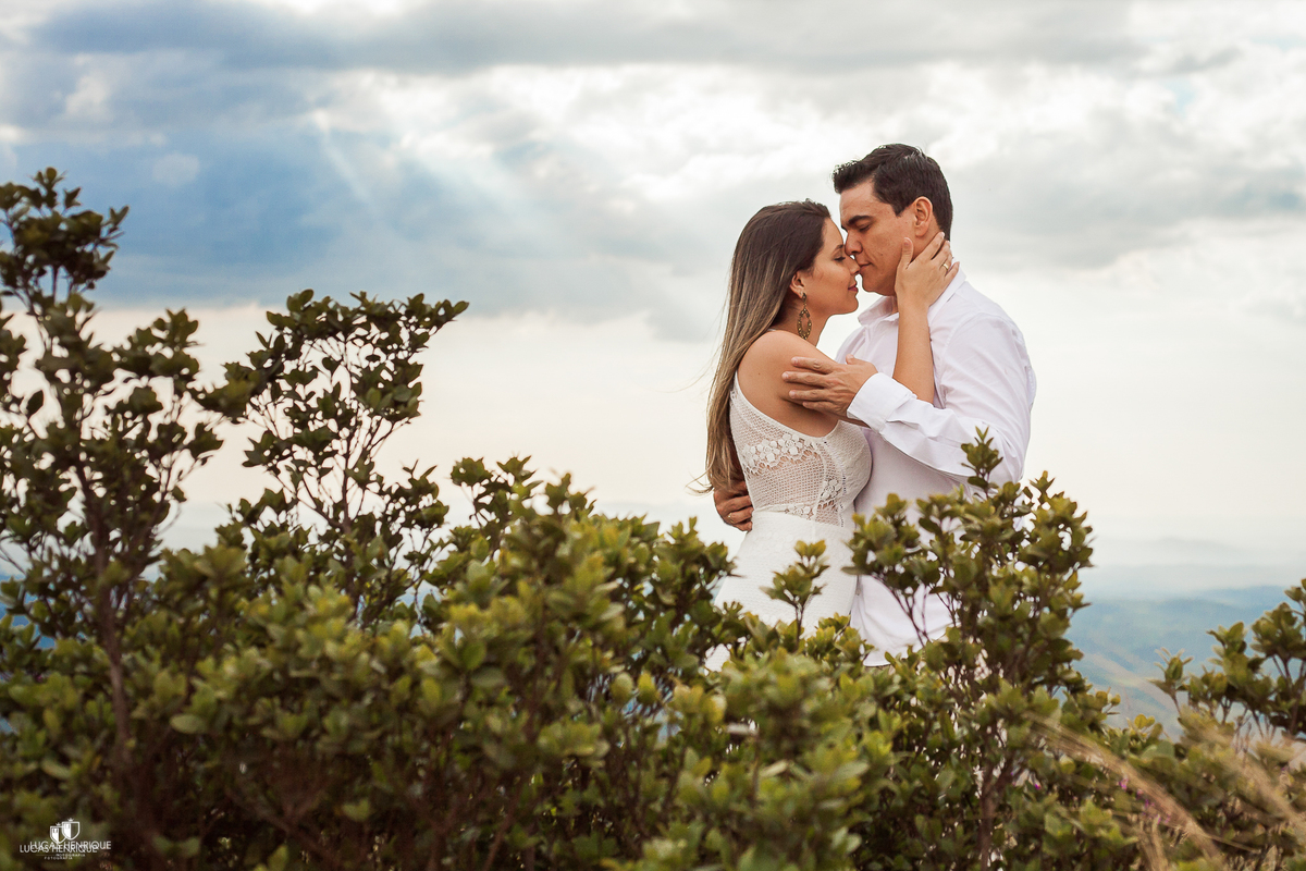 NOIVOS ABRAÇADOS COM CEU AZUL NO TOPO DO MUNDO