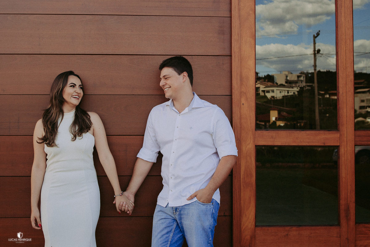 FOTO DOS NOIVOS DE MÃOS DADAS NA PORTA DE MADEIRA
