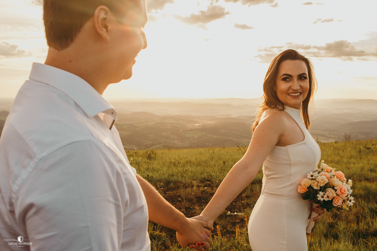 FOTO DOS NOIVOS DE MÃOS DADAS NO POR DO SOL
