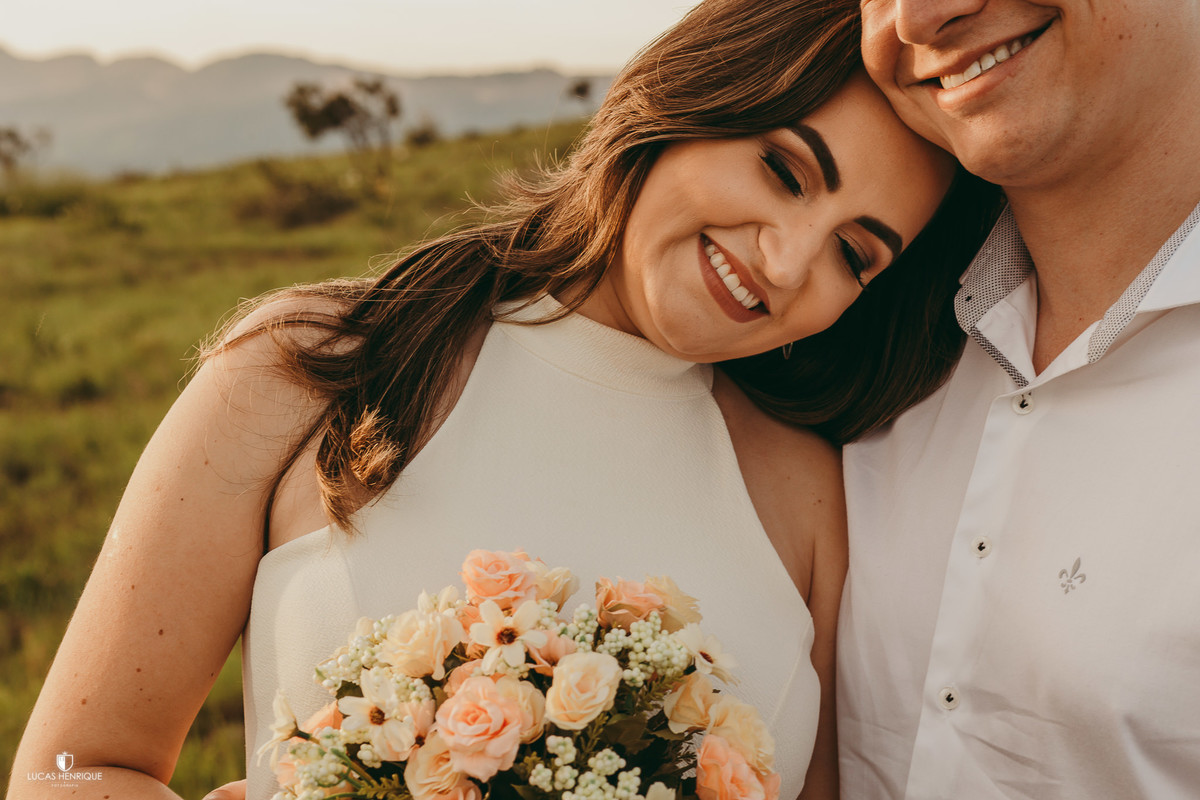 FOTOS DA NOIVA DEITADA NO OMBRO DO NOIVO COM POR DO SOL E BOUQUE