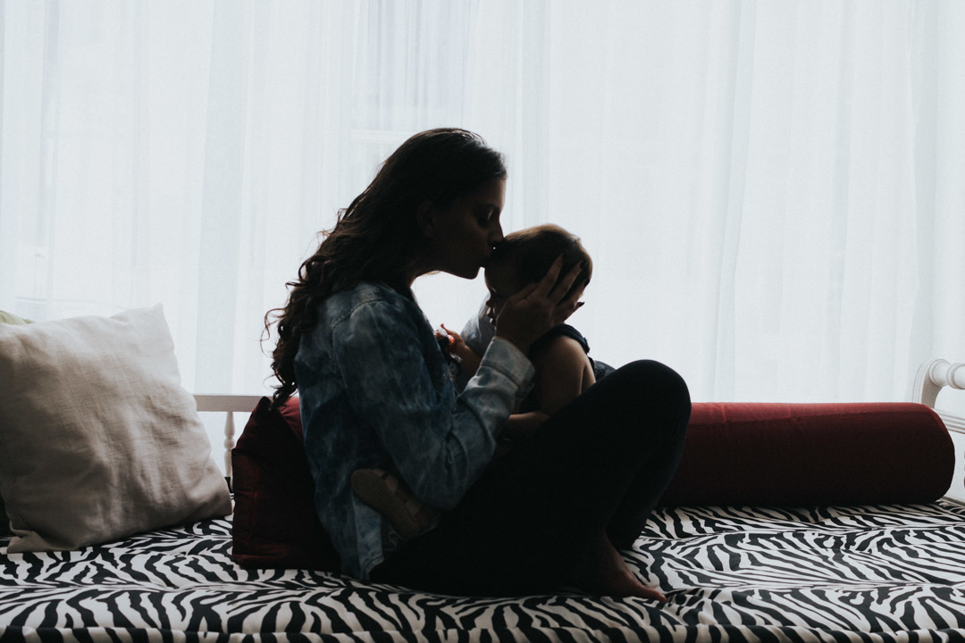 Mãe dando beijo na testa do filho