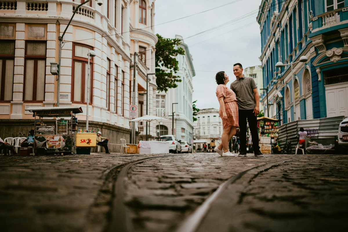 Casal no meio da rua com trilhos de trem