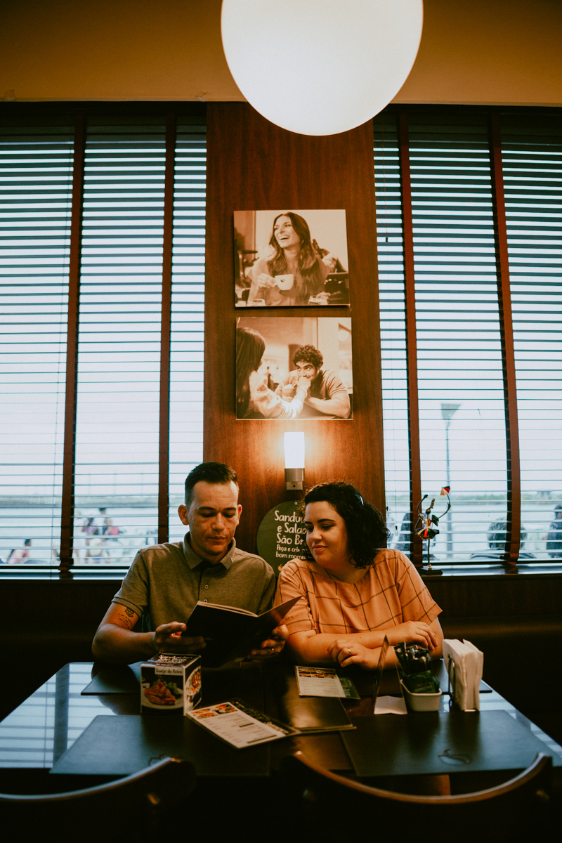 Casal na cafeteria olhando o cardápio