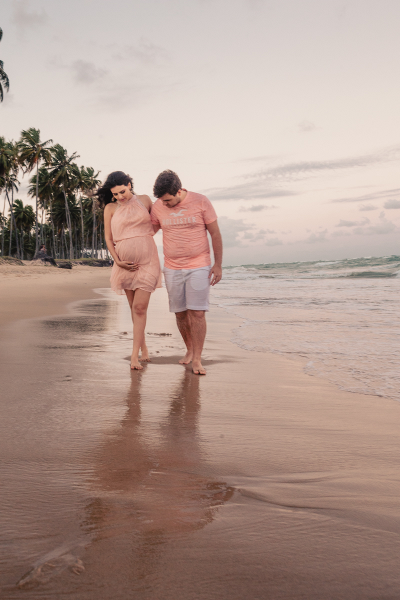 Casal caminhando na areia da praia
