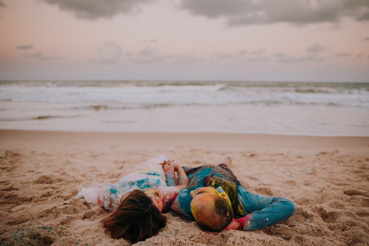 casal deitado na areia da praia