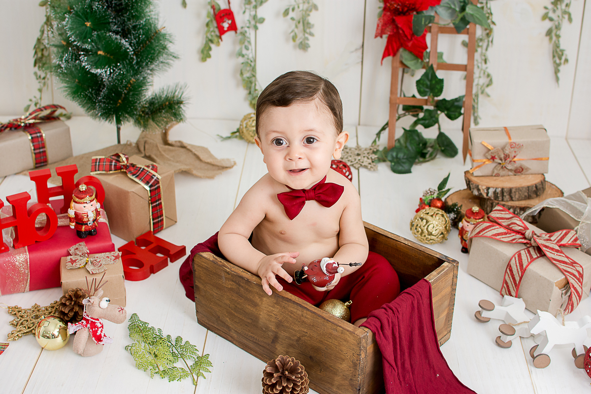 um bebe brincando no cenario de natal do estudio amora e foi fotografado por nailie lucchesi