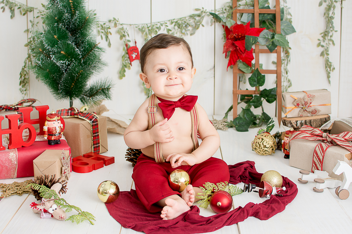 um bebe brincando no cenario de natal do estudio amora e foi fotografado por nailie lucchesi