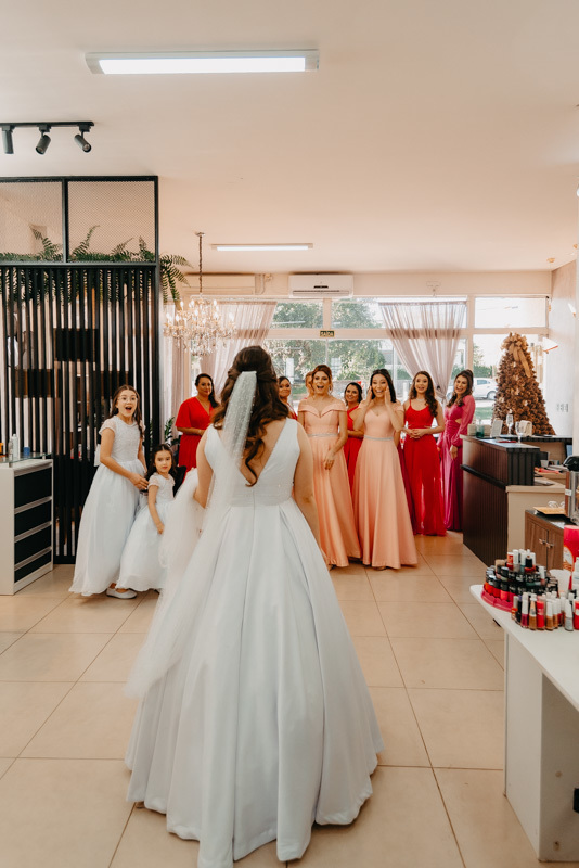 casamento por marcus espindola fotografia ano 2022 momentos do making da noiva pronta com o vestido e veu enorme e buque fazendo o first look com as madrinhas surpresa