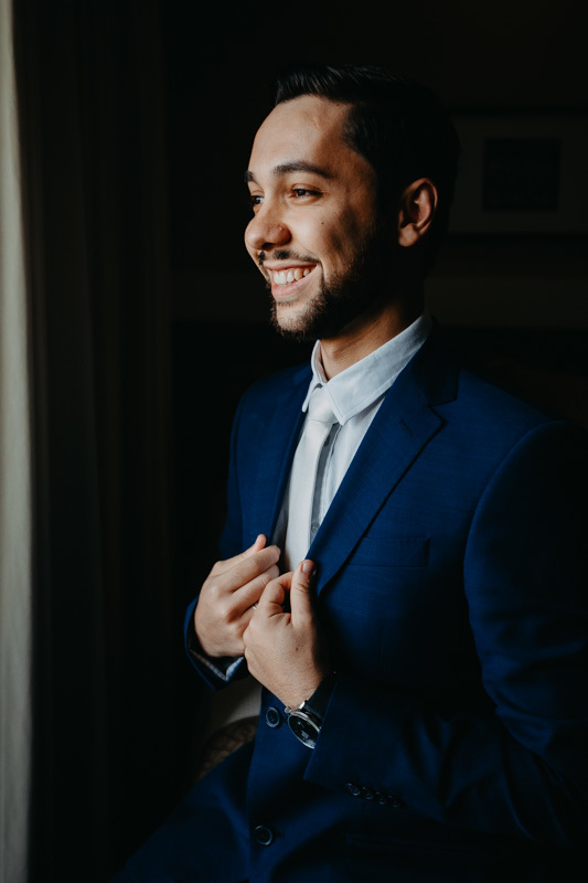 casamento por marcus espindola fotografia ano 2022 momentos do making da noivo se arrumando em hotel villas foto de detalhes e noivo sorrindo e olhando ao horizonte