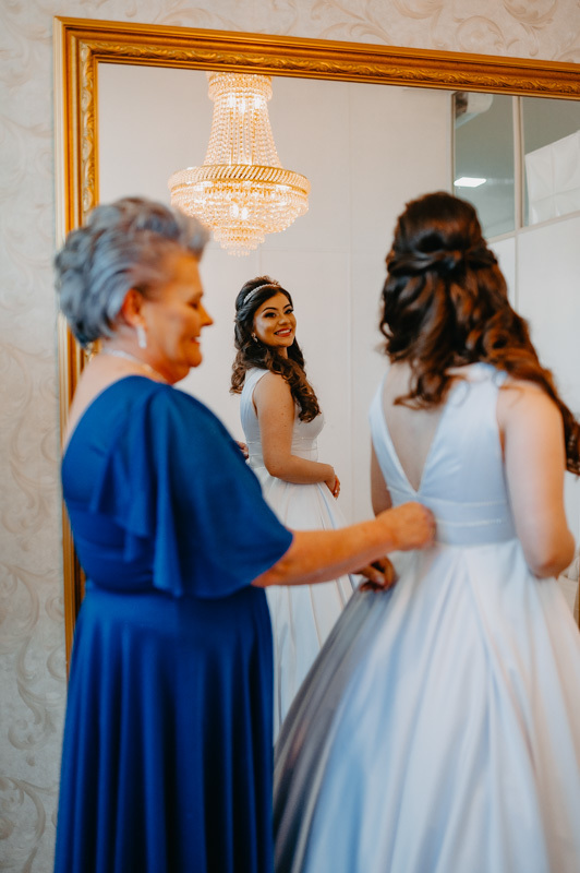 casamento por marcus espindola fotografia ano 2022 momentos do making da noiva mae ajudando arrumar noiva fechando vestido
