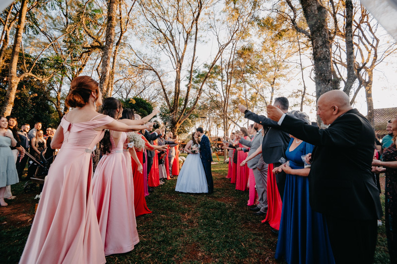 casamento por marcus espindola fotografia ano 2022 momentos da cerimonia de casamento ao ar livre e saida dos noivos com beijo e muito arroz jogado pelos familiares