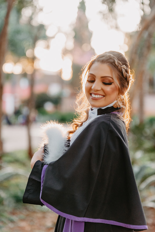 marcus-espindola-fotografia-de-formatura-na-praca-da-catedral-santo-angelo-pedagogia-com-toga-e-sorrindo
