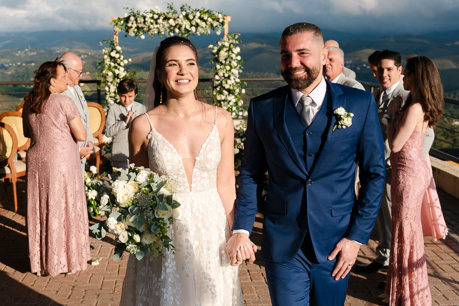 Recém-casados! Chico e Cacau radiantes na saída da cerimônia de casamento no Bendito Cacao. O cenário perfeito com vista para as montanhas de Campos do Jordão. Fotografia de casamento que captura a emoção e a beleza natural desse dia inesquecível.