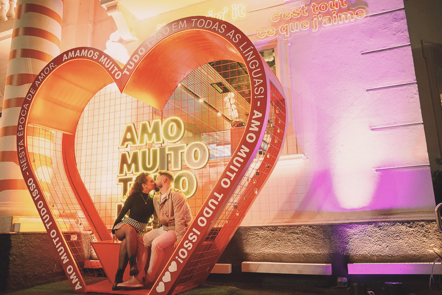 Foto criativa no Méqui 1000 na Avenida Paulista: casal namorando no cenário iluminado de coração