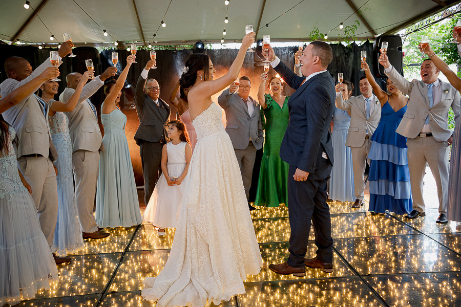 Um brinde à felicidade compartilhada! Noivos e padrinhos erguem as taças na incrível pista de led do Recanto Serimbura. A energia vibrante de celebrar o amor cercado de amigos queridos em São José dos Campos.