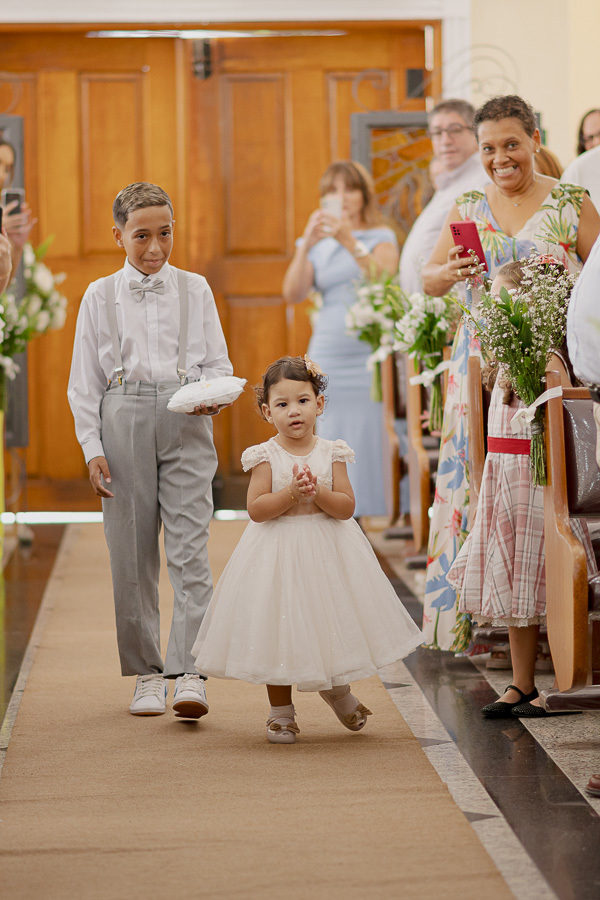 Fofura no altar! A entrada encantadora da daminha e do pajem roubando a cena na cerimônia. A inocência e a graça que derretem os corações na Paróquia Espírito Santo.