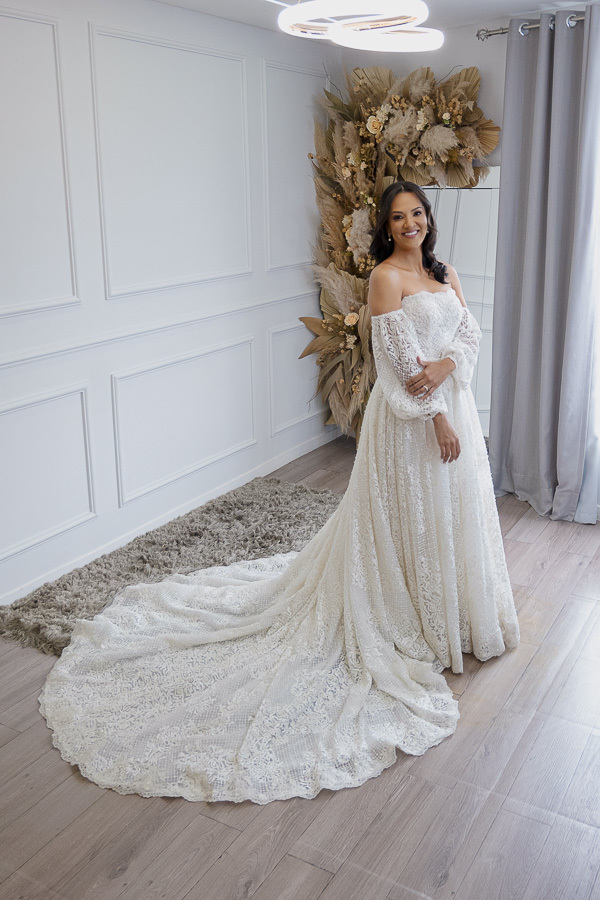 Volume e leveza. A noiva finaliza a produção, revelando a beleza da saia rodada toda em renda. Um look nupcial clássico e deslumbrante para casamentos no Vale do Paraíba.