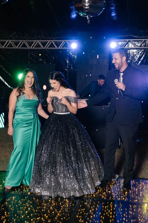 Alegria contagiante! Risadas sinceras entre mãe e filha durante o cerimonial marcam este momento leve e inesquecível da festa de 15 anos. A verdadeira essência da celebração é a felicidade espontânea.