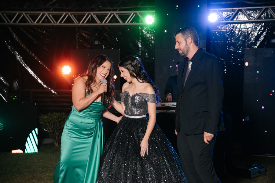 União e diversão! Após a formalidade, a família celebra junta na pista de dança de LED. Sorrisos e abraços espontâneos que mostram a conexão especial e o amor envolvido nesta festa de 15 anos mágica.