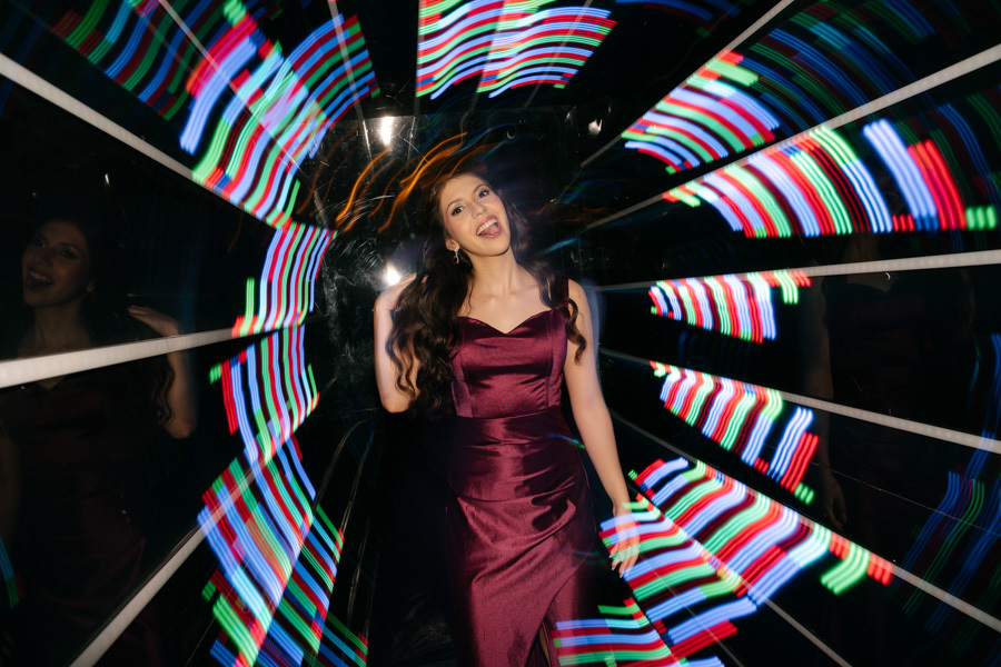 Elegância e atitude! A debutante brilha em seu vestido marsala com fenda, posando com confiança à frente da estrutura do DJ. Uma fotografia de 15 anos que destaca a beleza e o estilo único da aniversariante.