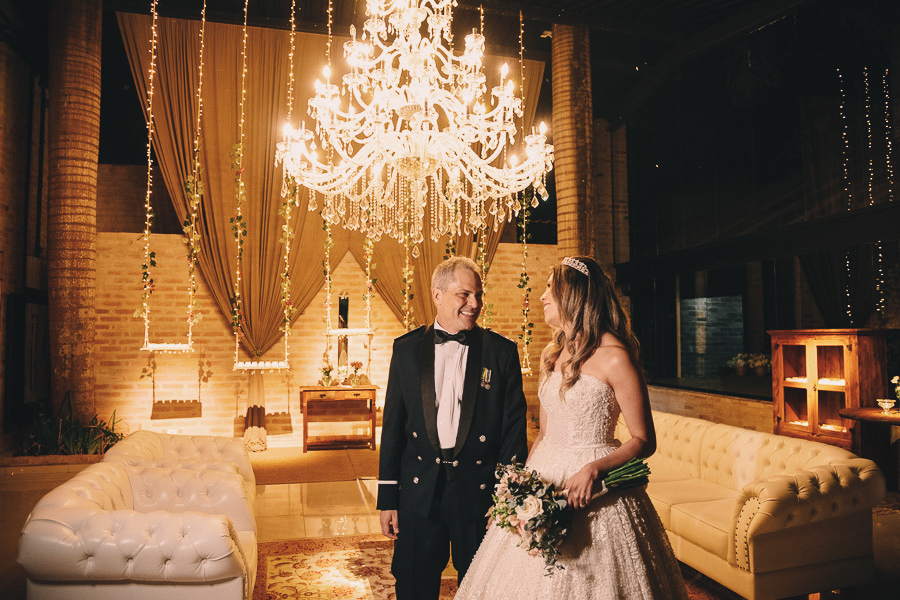 Decoração de casamento sofisticada no Amadeus Buffet Crystal: noivos posando sob lustres de cristal na recepção