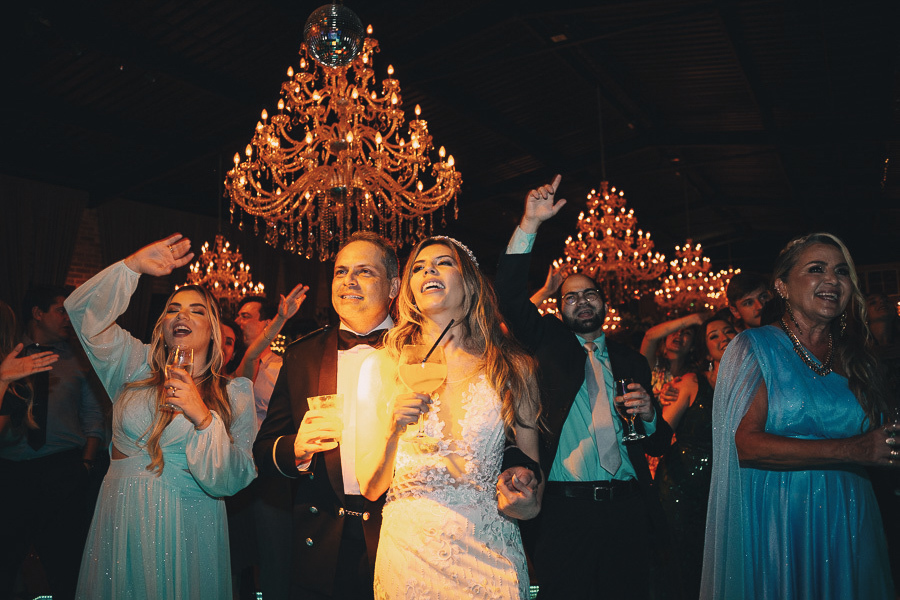 Festa de casamento animada no Amadeus Buffet em Taubaté: noivos brindando e celebrando na pista de dança