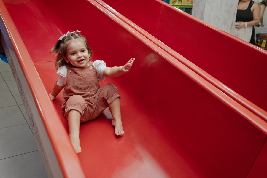 Lá vem ela! Adoro os cliques cheios de ação que mostram a coragem e a animação dos pequenos. Cada descida no escorregador é um flash de pura felicidade.