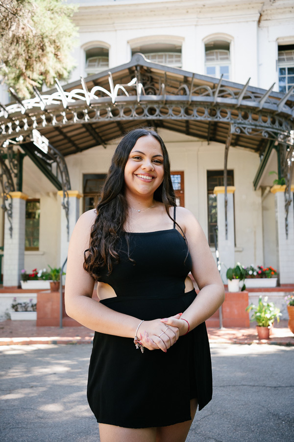 Sorriso espontâneo: Camila relaxando durante a sessão de fotos. Momentos descontraídos que refletem a essência dos 15 anos.