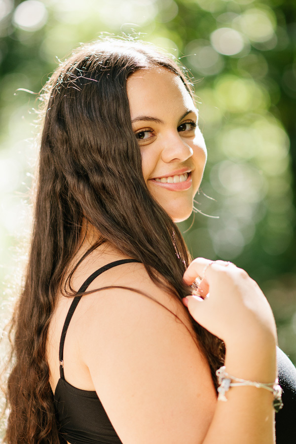 Espontaneidade e vento: O movimento natural dos cabelos ao ar livre. Fotografia de retrato feminino com luz natural.