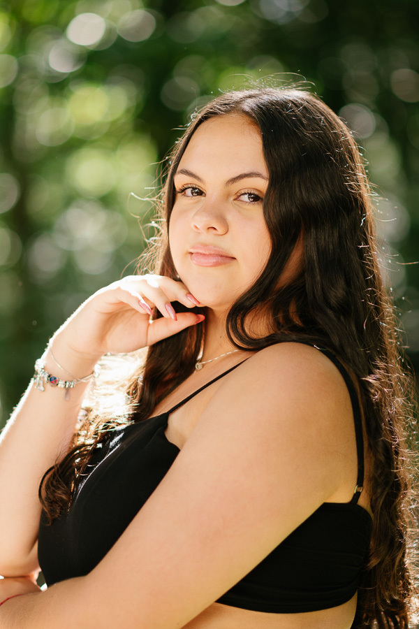 Delicadeza nos detalhes: A mão próxima ao rosto emoldurando o olhar. Poses clássicas e atemporais para book de debutante.