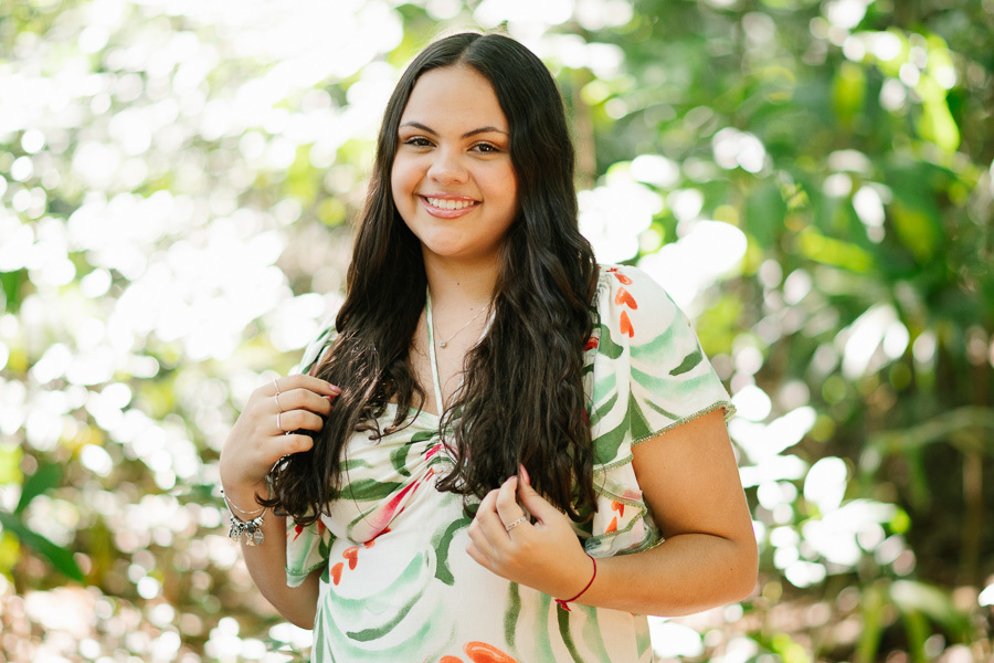 Conexão com a natureza: Debutante sentada no jardim do Vicentina Aranha. Fotos leves e românticas para celebrar os 15 anos.
