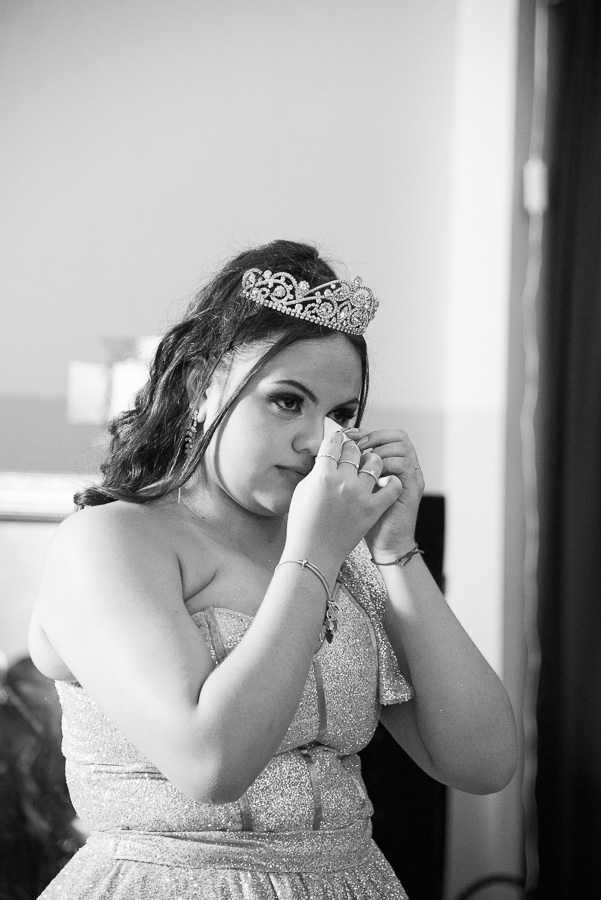 Close colorido: A aniversariante enxuga uma lágrima, mostrando a intensidade dos sentimentos vividos.