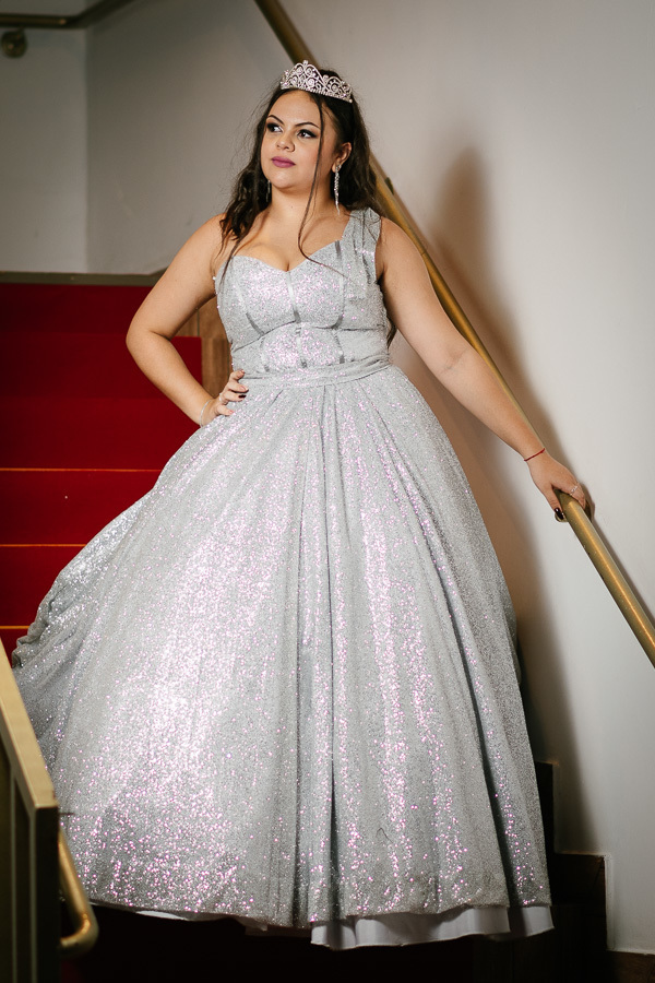 Entrada triunfal: A debutante no topo da escadaria com tapete vermelho, valorizando o espaço de eventos.Foto oficial dos 15 casais: A elegância dos amigos em trajes de gala posando na escadaria do Lisbon.