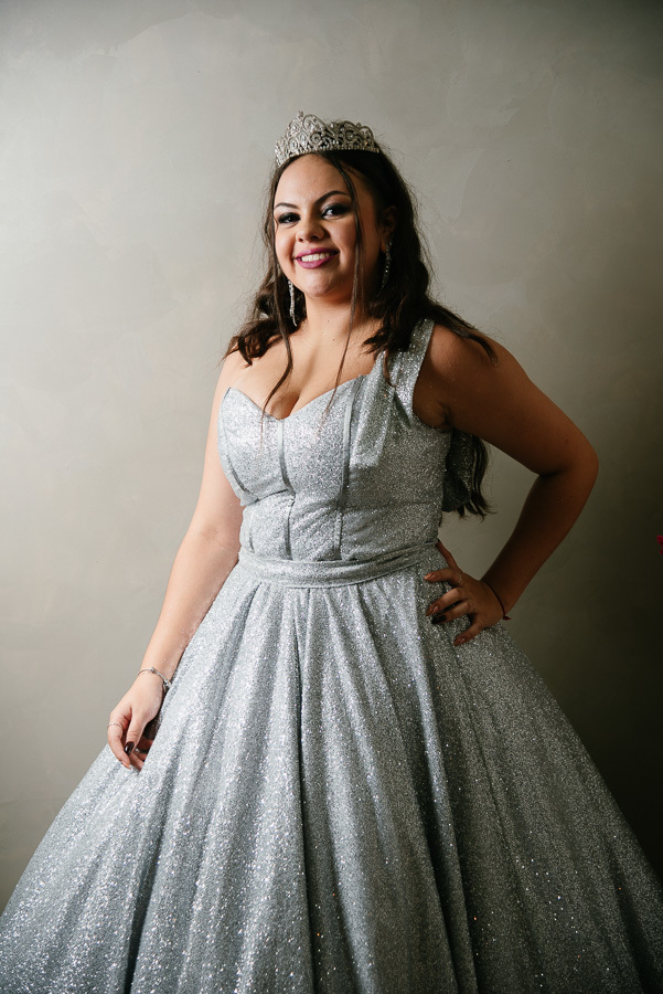 Fotografia natural: Um momento de timidez e charme, com a debutante olhando para baixo e sorrindo.