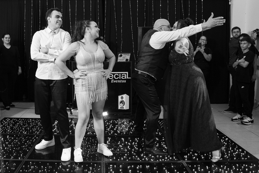 Fotografia de casais: Um beijo apaixonado capturado no meio da pista de dança, celebrando o amor.